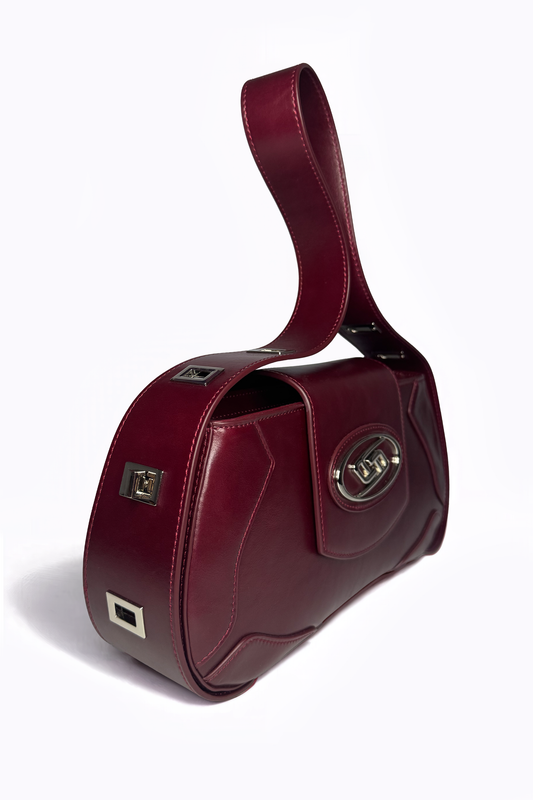 A study in tactile luxury: The Downtown Bag by AYZAHD captures the magnetic, deep crimson depth of Emira Rouge on its grained oiled soft calfskin. A sculptural silhouette designed in Dubai with quiet, uncompromising intention.
