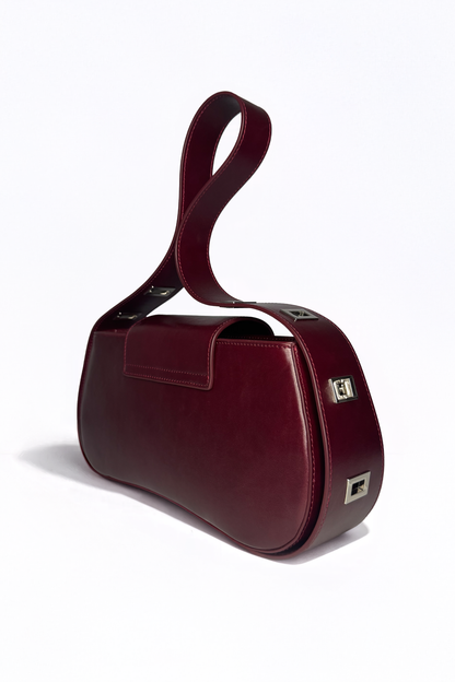 Defined by its rigid yet fluid elegance, The Downtown Bag by AYZAHD in Emira Rouge challenges traditional leatherwork. An architectural masterpiece in grained oiled soft calfskin, proudly conceived and designed in Dubai.